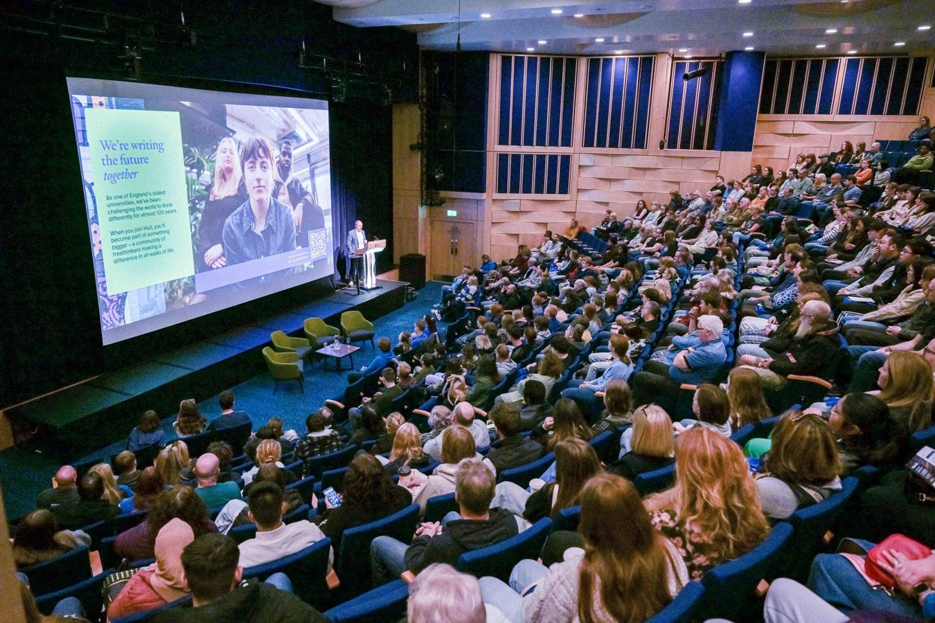 A room full of people listening to the welcome talk at an open day