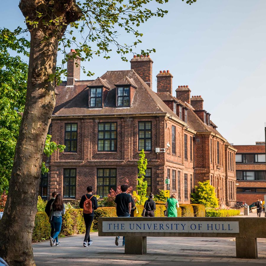 Students walking past University Sign