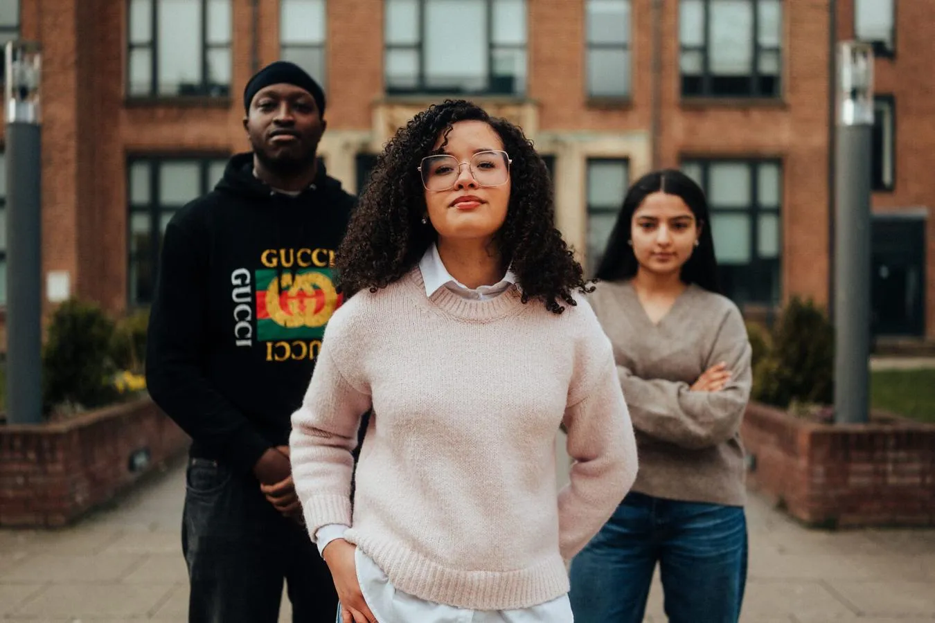 Three of Hull’s students stand confidently together in front of an ornate entrance to the Library
