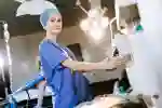 Student in blue hospital scrubs in an operating theatre
