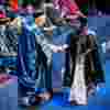 Student shaking hands with robed University chancellor on the graduation stage
