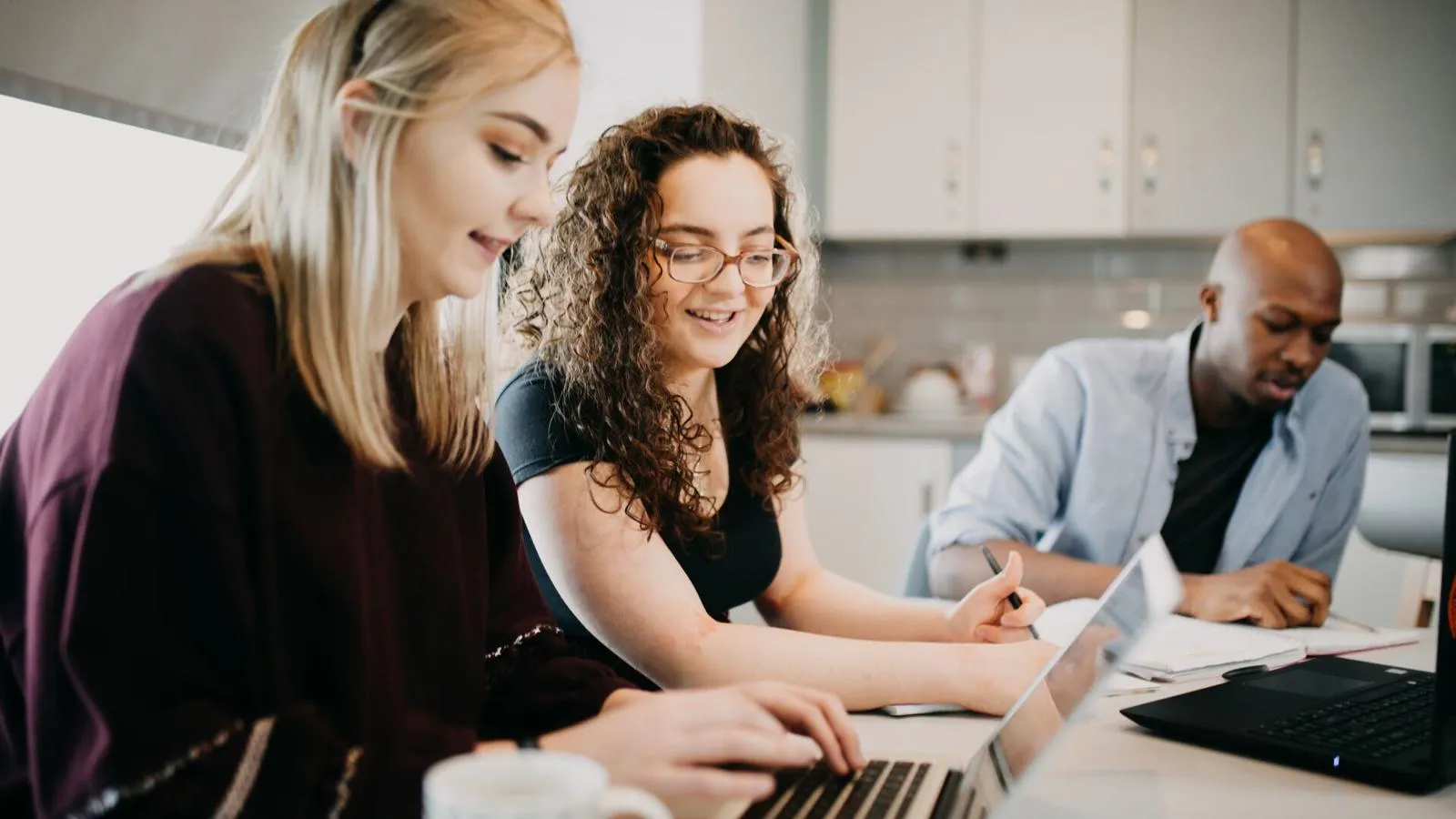 A busy kitchen with students studying and eating