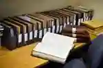 An open book on a table of files.