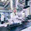 A researcher pours chemicals into machinery at the Aura Innovation Centre