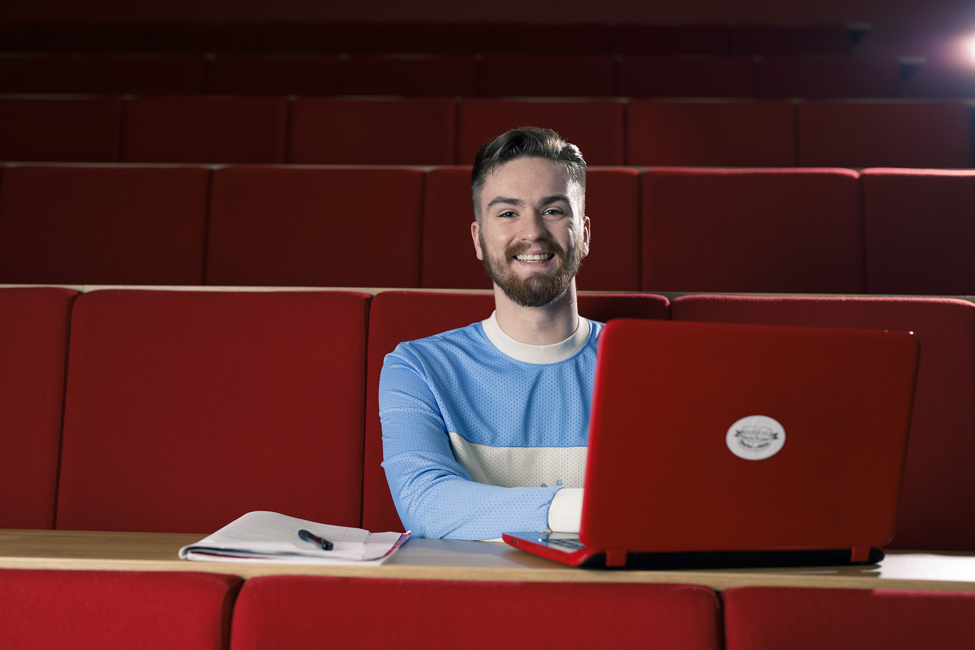 student sat in lecture theatre with laptop open