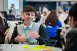 Student laughing while working with another student