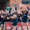 A rugby league team celebrating with a trophy.