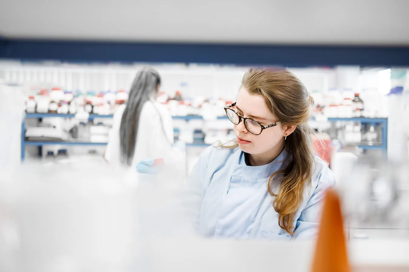 Two scientists in white coats working in a lab